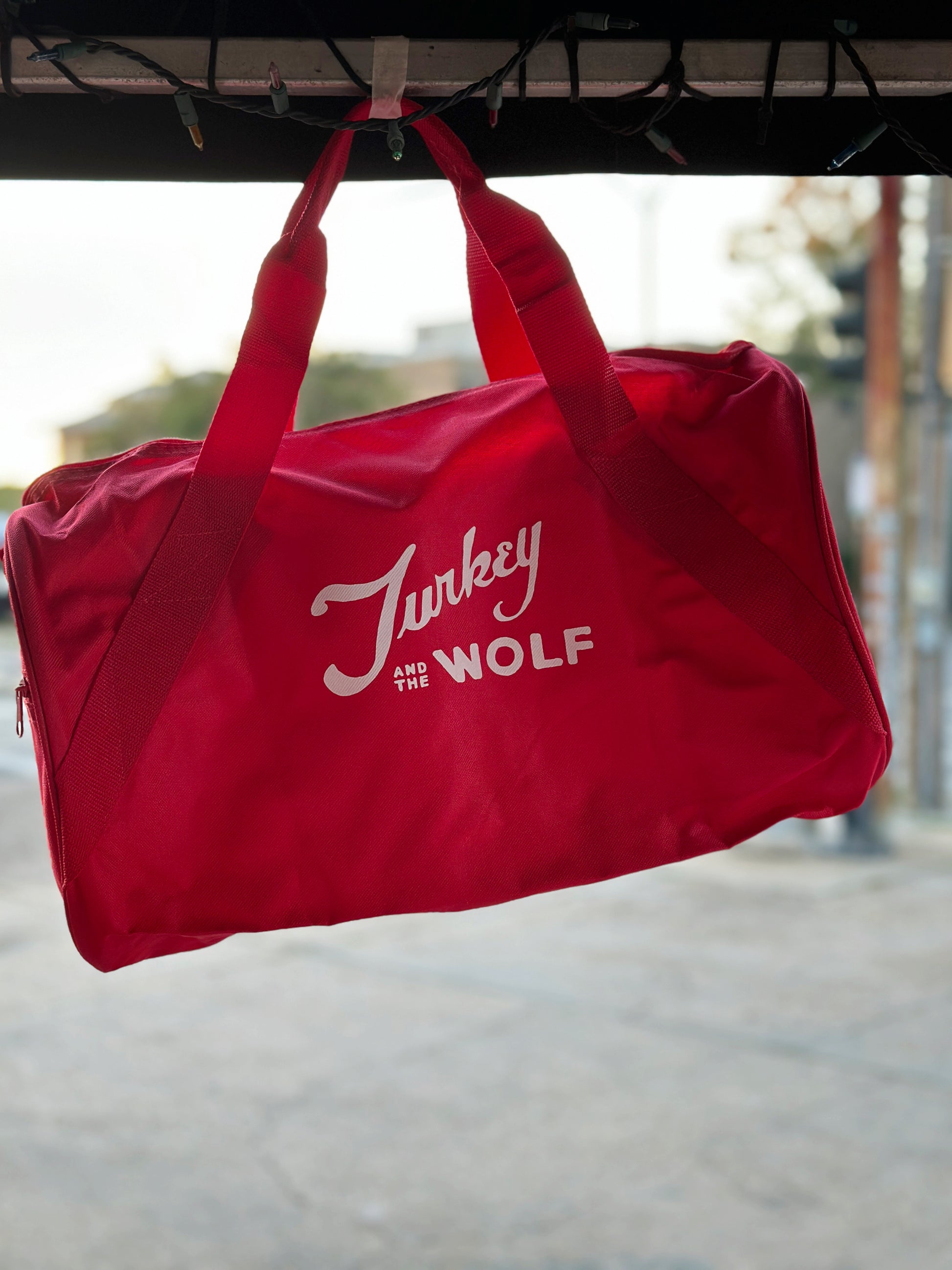 Red Duffle bag that says Turkey and the Wolf in white